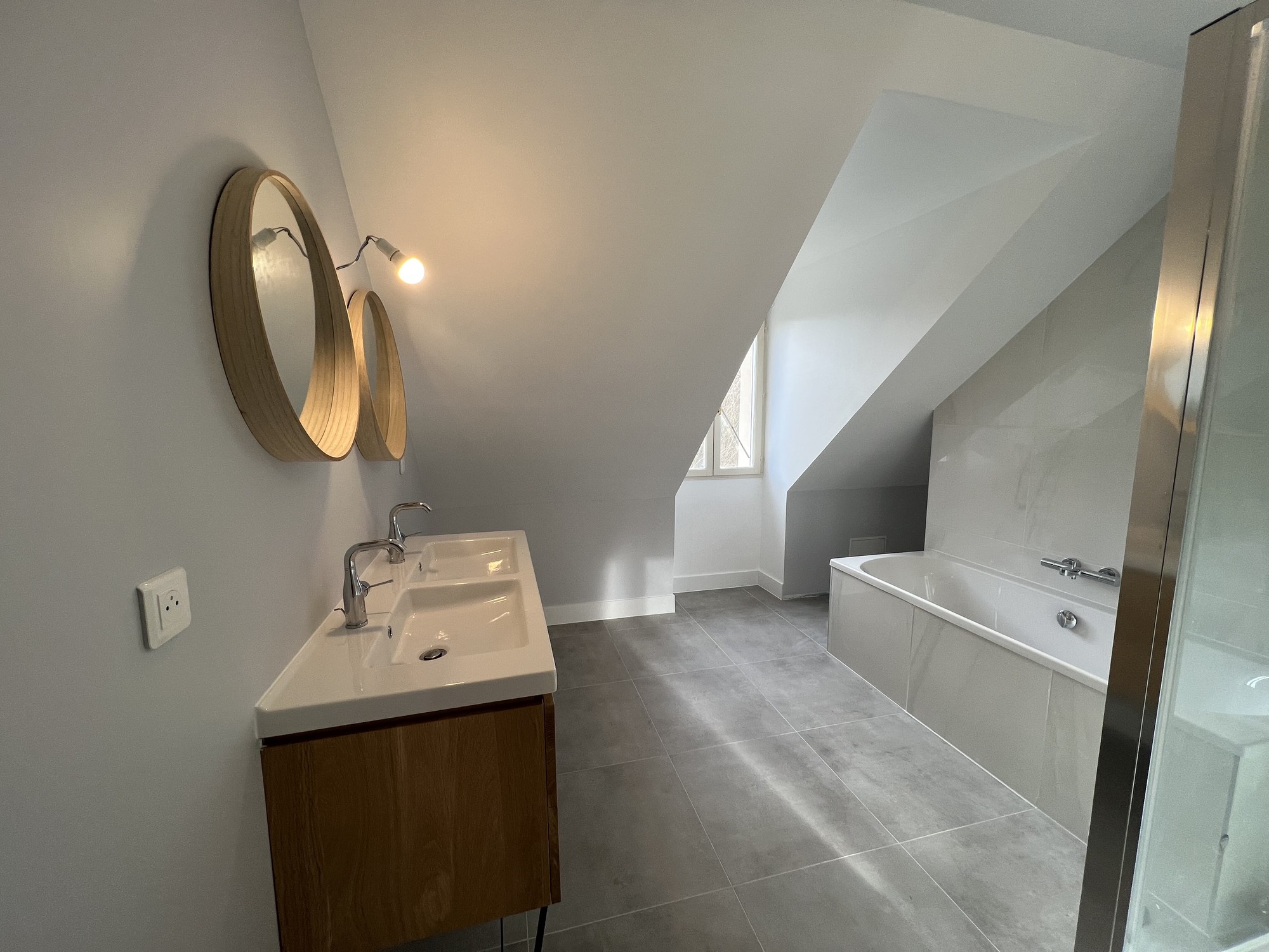 Salle de bain Thoiry avec baignoire, douche et double miroir sous combles